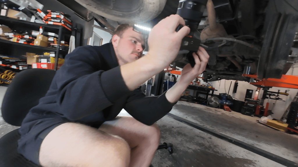 Filming under a lifted 4WD at a Southport workshop